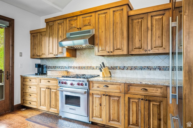 4121 Fairway Ln Unit A1, Park City, UT 84098 - kitchen with premium range, under cabinet range hood, light wood finished floors, backsplash, and vaulted ceiling