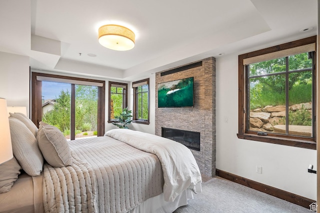 4121 Fairway Ln Unit A1, Park City, UT 84098 - bedroom featuring a tray ceiling, multiple windows, a stone fireplace, and carpet floors