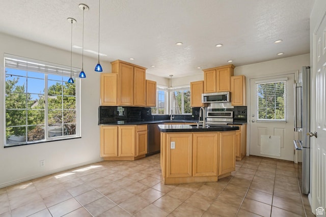 4964 Boulder Glen Cir, West Jordan, UT 84088 - kitchen with appliances with stainless steel finishes, dark countertops, decorative backsplash, recessed lighting, and a kitchen island with sink