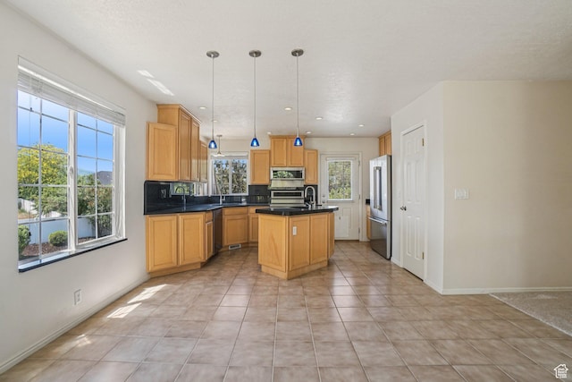 4964 Boulder Glen Cir, West Jordan, UT 84088 - kitchen with stainless steel appliances, a center island with sink, dark countertops, light tile patterned floors, and pendant lighting