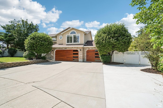 4964 Boulder Glen Cir, West Jordan, UT 84088 - view of front facade featuring a garage, driveway, a gate, and stucco siding