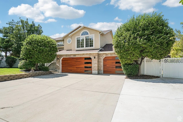 4964 Boulder Glen Cir, West Jordan, UT 84088 - view of front facade with a garage, concrete driveway, stucco siding, and brick siding