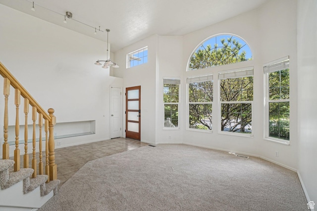 4964 Boulder Glen Cir, West Jordan, UT 84088 - carpeted entryway featuring a towering ceiling, stairway, and tile patterned flooring