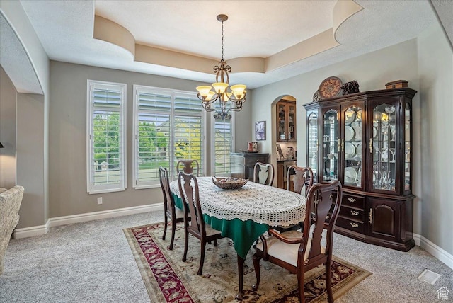 12937 S Old Country Ct W, Riverton, UT 84065 - dining space with light colored carpet, arched walkways, a chandelier, and a raised ceiling