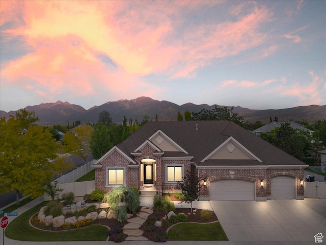 12937 S Old Country Ct W, Riverton, UT 84065 - view of front facade featuring brick siding, a mountain view, driveway, and an attached garage