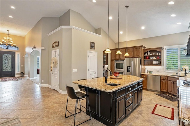 12937 S Old Country Ct W, Riverton, UT 84065 - kitchen featuring appliances with stainless steel finishes, arched walkways, a chandelier, an island with sink, and open shelves