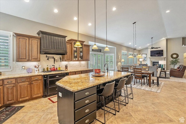 12937 S Old Country Ct W, Riverton, UT 84065 - kitchen with ventilation hood, a breakfast bar, backsplash, vaulted ceiling, and light stone counters