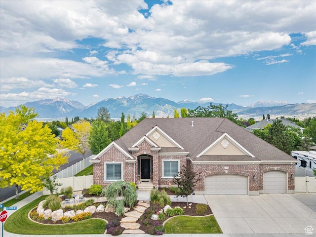 12937 S Old Country Ct W, Riverton, UT 84065 - view of front of home featuring a mountain view, an attached garage, brick siding, and driveway