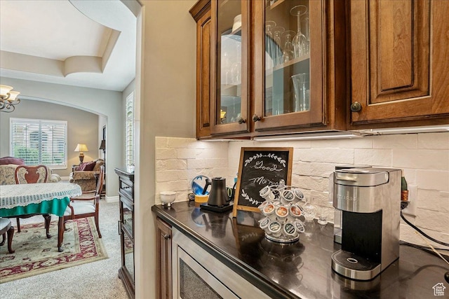 12937 S Old Country Ct W, Riverton, UT 84065 - detailed view of brown cabinets, carpet floors, glass insert cabinets, backsplash, and a chandelier