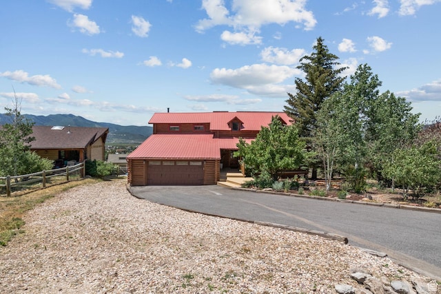 6385 Mountain View Dr, Park City, UT 84098 - view of front of house featuring asphalt driveway, a mountain view, a garage, and a metal roof