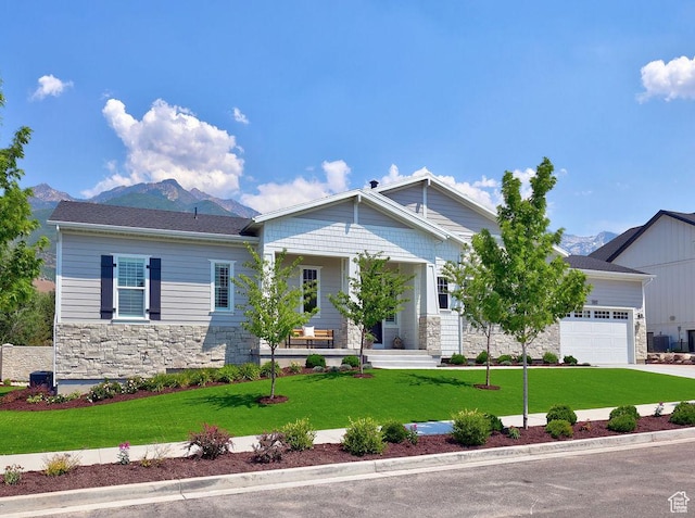 7817 S Danish Pine Ln Unit 101, Cottonwood Heights, UT 84121 - view of front facade with stone siding, a mountain view, a front lawn, and a porch