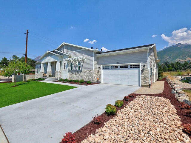 7817 S Danish Pine Ln Unit 101, Cottonwood Heights, UT 84121 - view of front of home with an attached garage, driveway, stone siding, a front yard, and a mountain view