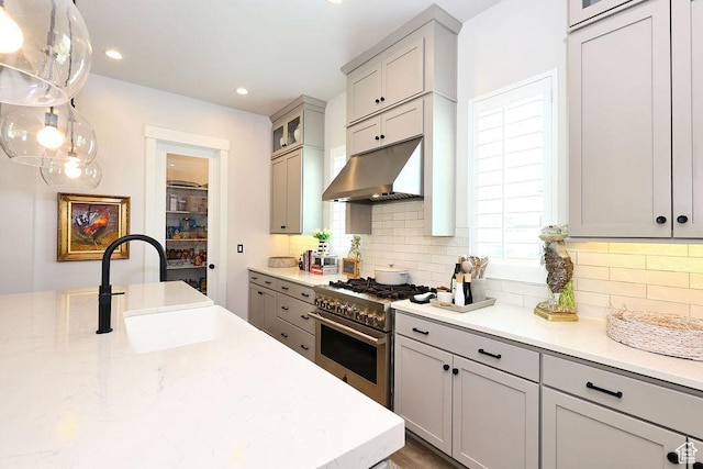 7817 S Danish Pine Ln Unit 101, Cottonwood Heights, UT 84121 - kitchen featuring high end stove, under cabinet range hood, gray cabinetry, tasteful backsplash, and recessed lighting