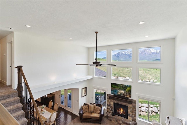 6167 N Hidden Hills Dr, Mountain Green, UT 84050 - living area with a stone fireplace, dark wood-style flooring, ceiling fan, a high ceiling, and recessed lighting