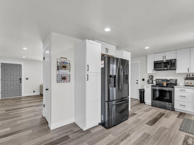 4332 W Losee Dr, West Valley City, UT 84120 - kitchen with appliances with stainless steel finishes, light wood-style floors, white cabinetry, light countertops, and recessed lighting
