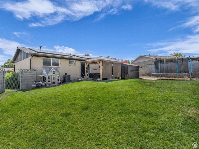 4332 W Losee Dr, West Valley City, UT 84120 - rear view of house with a trampoline, a gazebo, a fenced backyard, brick siding, and solar panels