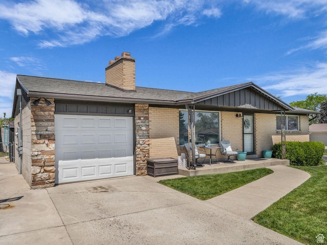 4332 W Losee Dr, West Valley City, UT 84120 - view of front of home with board and batten siding, a garage, concrete driveway, brick siding, and a chimney