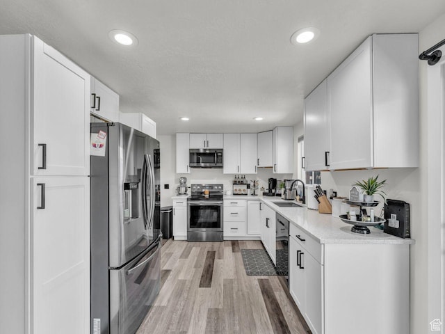 4332 W Losee Dr, West Valley City, UT 84120 - kitchen featuring stainless steel appliances, light wood-style floors, white cabinets, and recessed lighting