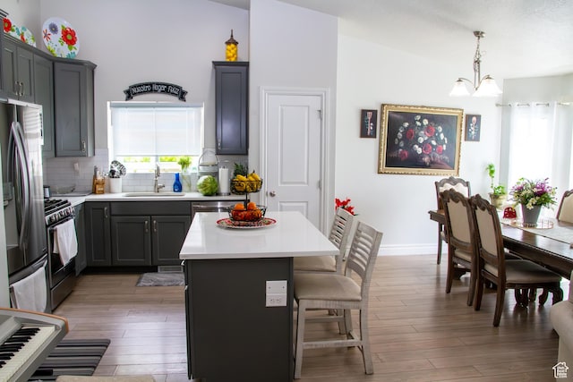 1415 N 3300 W, Provo, UT 84601 - kitchen featuring stainless steel refrigerator with ice dispenser, light wood-style flooring, a kitchen breakfast bar, backsplash, and gas range oven