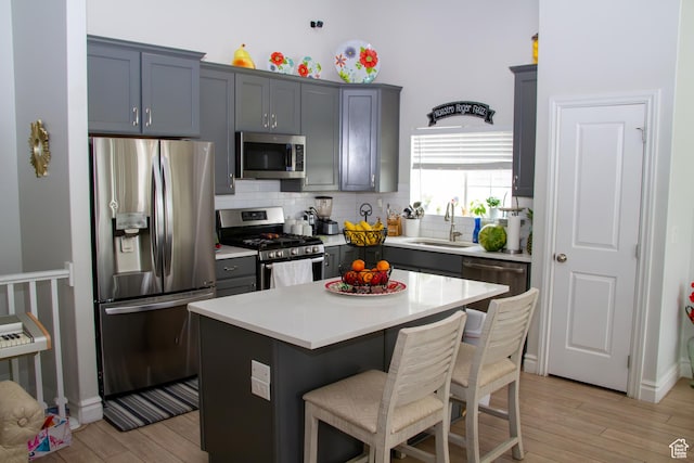 1415 N 3300 W, Provo, UT 84601 - kitchen featuring appliances with stainless steel finishes, decorative backsplash, light wood-type flooring, a kitchen breakfast bar, and light countertops