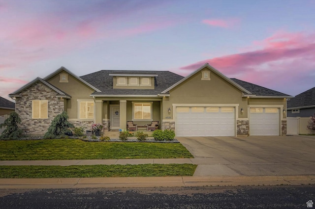 4909 N Cliffrose Dr, Eagle Mountain, UT 84005 - view of front of home with stone siding, stucco siding, a porch, and concrete driveway