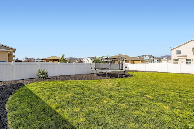 4909 N Cliffrose Dr, Eagle Mountain, UT 84005 - fenced backyard featuring a trampoline and a residential view