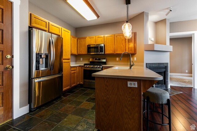 8050 Gambel Dr Unit O-1, Park City, UT 84098 - kitchen featuring stainless steel appliances, a peninsula, light countertops, a kitchen breakfast bar, and pendant lighting