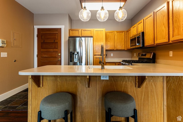 8050 Gambel Dr Unit O-1, Park City, UT 84098 - kitchen with stainless steel appliances, light countertops, a peninsula, a breakfast bar area, and decorative light fixtures
