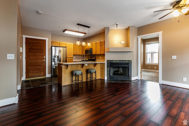 8050 Gambel Dr Unit O-1, Park City, UT 84098 - kitchen featuring appliances with stainless steel finishes, a peninsula, dark wood finished floors, a breakfast bar, and ceiling fan