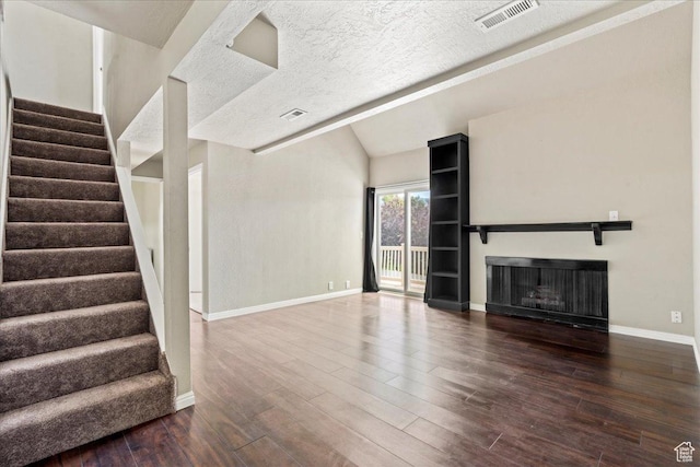 88 W 50 S Unit C9, Centerville, UT 84014 - unfurnished living room featuring a fireplace, wood finished floors, stairs, vaulted ceiling, and a textured ceiling