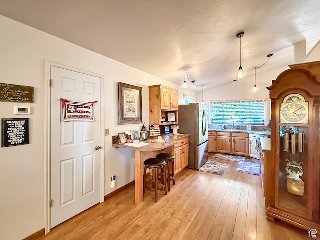 280 W 2400 S, Perry, UT 84302 - kitchen with freestanding refrigerator, light wood finished floors, light countertops, light brown cabinetry, and vaulted ceiling