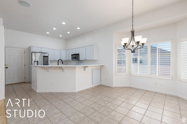 1209 N 1120 W, Clinton, UT 84015 - kitchen featuring stainless steel appliances, a breakfast bar area, a peninsula, light countertops, and a chandelier