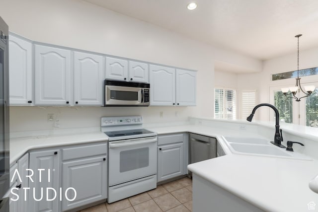 1209 N 1120 W, Clinton, UT 84015 - kitchen with appliances with stainless steel finishes, light tile patterned flooring, decorative light fixtures, white cabinets, and recessed lighting