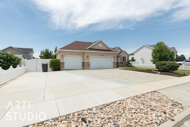 1209 N 1120 W, Clinton, UT 84015 - view of front of home with driveway, an attached garage, stucco siding, and stone siding