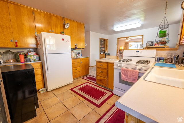 115 N Main St, Malad City, ID 83252 - kitchen featuring white appliances, light countertops, brown cabinets, and light tile patterned flooring
