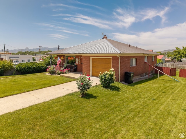 115 N Main St, Malad City, ID 83252 - view of front facade featuring an attached garage, a metal roof, a mountain view, brick siding, and a chimney