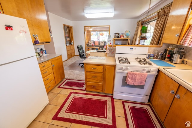115 N Main St, Malad City, ID 83252 - kitchen featuring white appliances, light countertops, brown cabinets, and light tile patterned floors