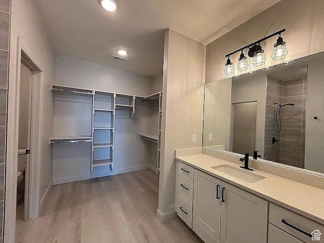 840 N Twin Lakes Dr Unit 414, St George, UT 84790 - bathroom with wood finished floors, vanity, a walk in closet, and tiled shower