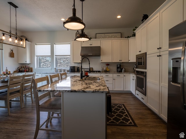 4821 W Juniper Bend Cir Unit 101, Herriman, UT 84096 - kitchen with appliances with stainless steel finishes, recessed lighting, under cabinet range hood, white cabinetry, and dark wood-type flooring
