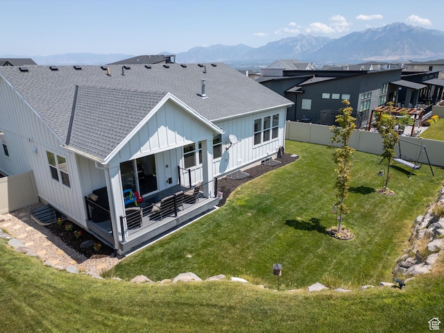4821 W Juniper Bend Cir Unit 101, Herriman, UT 84096 - rear view of house with board and batten siding, a shingled roof, a mountain view, a fenced backyard, and an outdoor living space