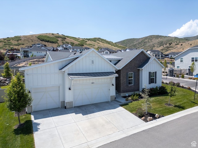 4821 W Juniper Bend Cir Unit 101, Herriman, UT 84096 - modern farmhouse featuring board and batten siding, a garage, driveway, and a mountain view