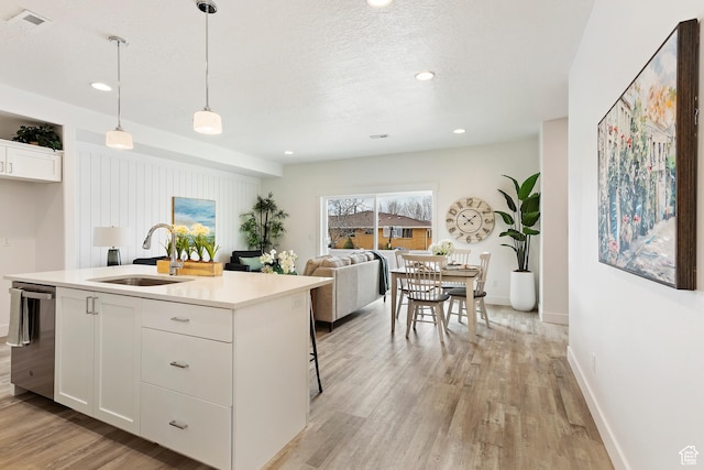 1695 W 2770 S Unit 203, Syracuse, UT 84075 - kitchen featuring light wood-type flooring, stainless steel dishwasher, white cabinetry, light countertops, and recessed lighting
