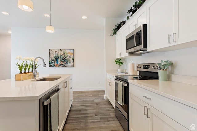 1695 W 2770 S Unit 203, Syracuse, UT 84075 - kitchen featuring appliances with stainless steel finishes, light countertops, wood finished floors, white cabinets, and decorative light fixtures