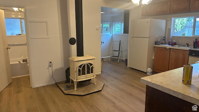 472 N 500 W, Logan, UT 84321 - kitchen with white appliances, light wood-style flooring, a wood stove, and light countertops
