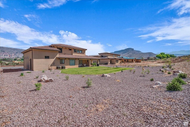 385 E Entrada Dr, Virgin, UT 84779 - rear view of house featuring a tile roof, stucco siding, a mountain view, and a yard
