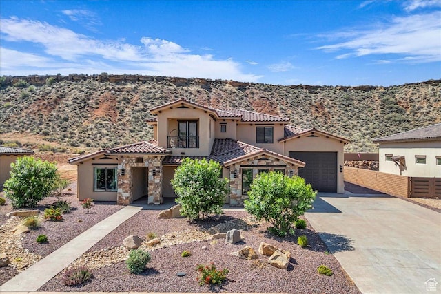 385 E Entrada Dr, Virgin, UT 84779 - mediterranean / spanish home with stucco siding, concrete driveway, a tiled roof, stone siding, and a mountain view