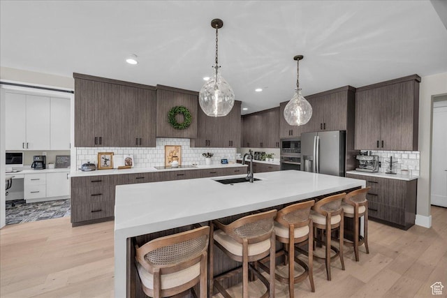 385 E Entrada Dr, Virgin, UT 84779 - kitchen with appliances with stainless steel finishes, backsplash, dark brown cabinetry, a kitchen bar, and modern cabinets