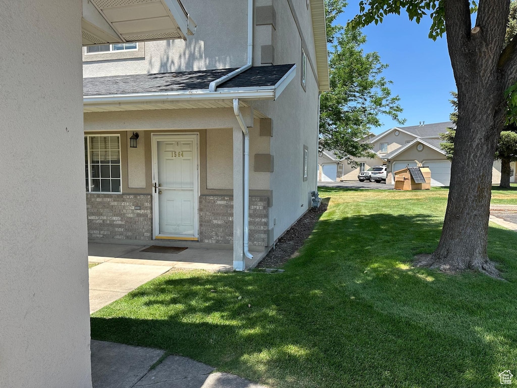 1564 S Talon, Logan, UT 84321 - doorway to property with stucco siding, a yard, and a shingled roof