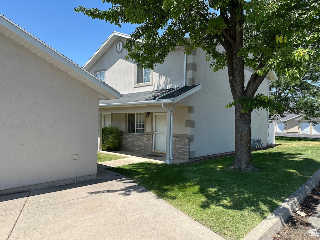 1564 S Talon, Logan, UT 84321 - view of front of house with a front yard, stucco siding, and brick siding