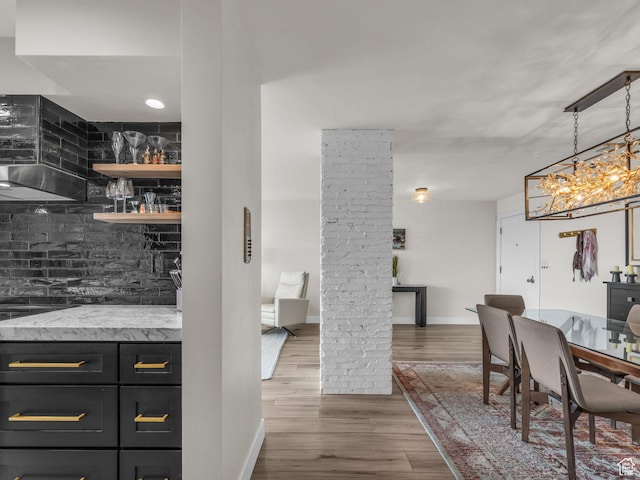 777 E S Temple Unit 5A, Salt Lake City, UT 84102 - bar featuring ornate columns, wood finished floors, ventilation hood, backsplash, and a chandelier